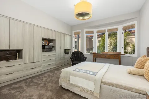 a bedroom with a bed and a large window