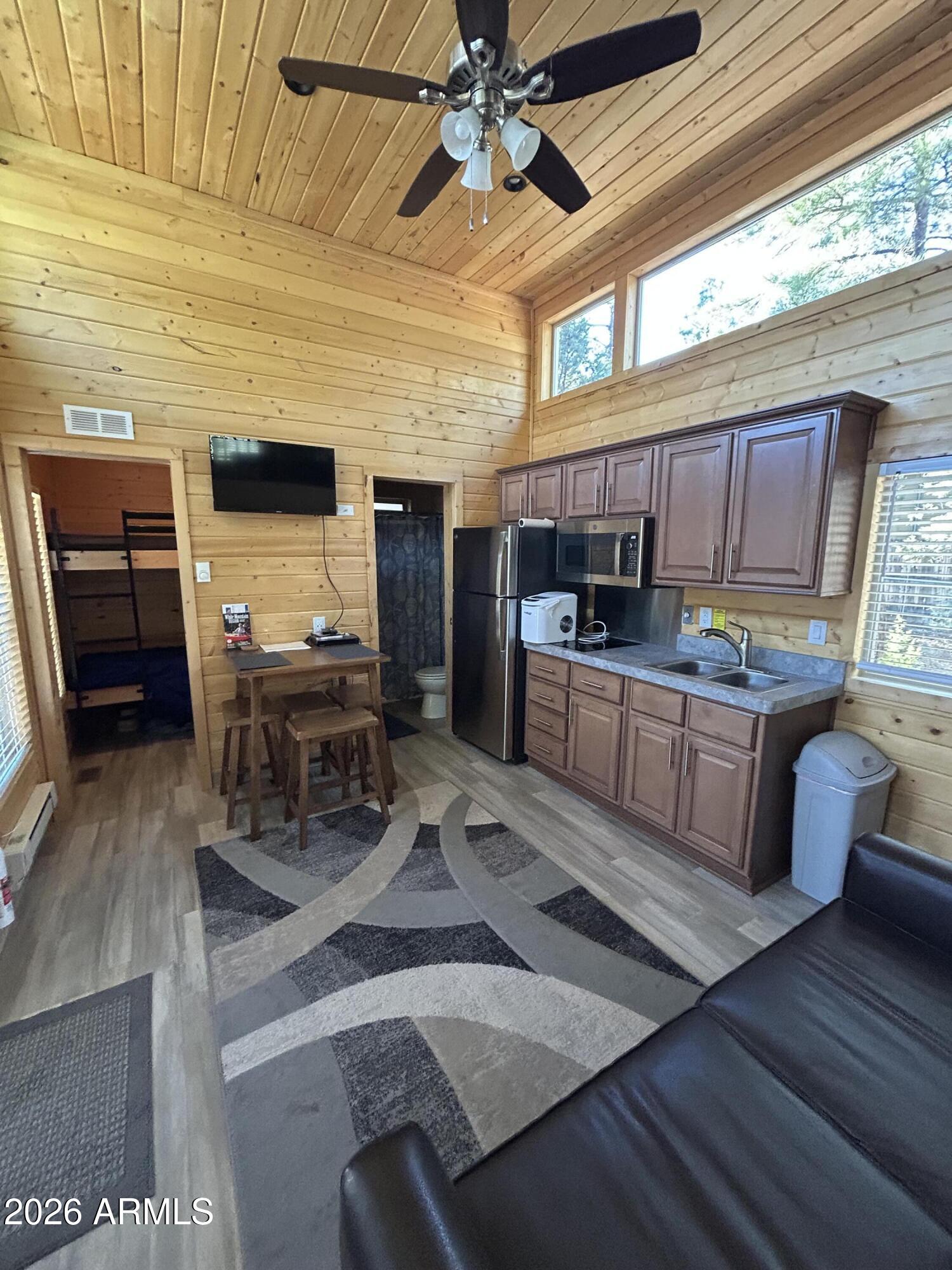 4020 South Elk Trot Loop Show Low, AZ 85901 - Photo 9 of 33 a kitchen with stainless steel appliances kitchen island granite countertop a table chairs in it and wooden floors
