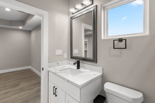 a bathroom with a toilet a sink a vanity and mirror