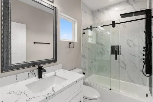 a bathroom with a granite countertop sink toilet and shower