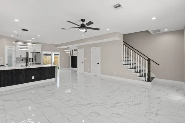 a view of an empty room with window and a ceiling fan