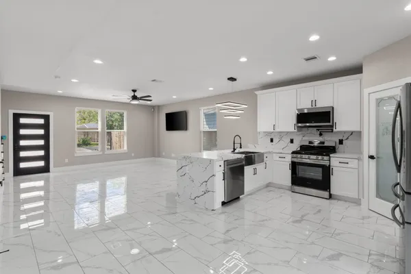 a large kitchen with stainless steel appliances granite countertop a stove and a sink