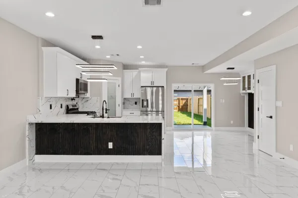 a view of kitchen with stainless steel appliances granite countertop a refrigerator and a sink