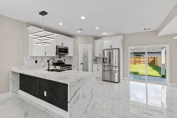 a kitchen with stainless steel appliances a refrigerator sink and stove
