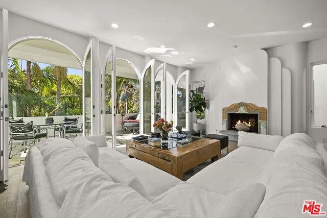 a living room with furniture fireplace and large windows