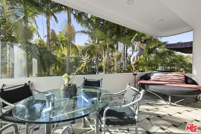 a table and chairs with the view of tree in front of it
