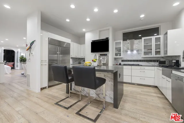 a kitchen with stainless steel appliances kitchen island granite countertop a sink and cabinets