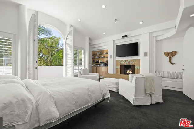 a spacious bedroom with a balcony a bed and a fireplace