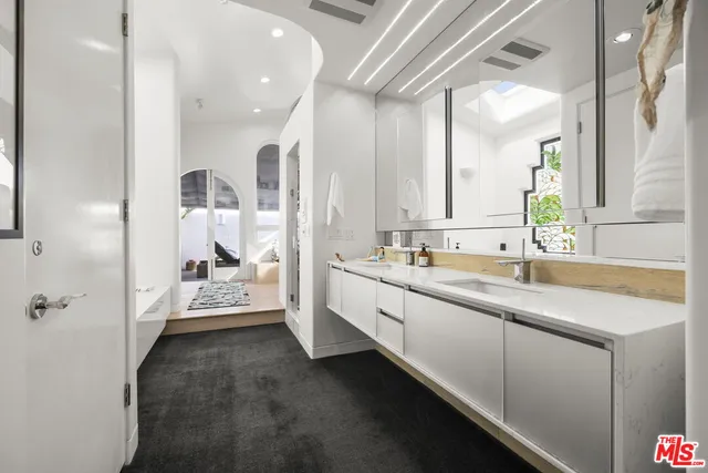 a spacious bathroom with a double vanity sink a mirror and a shower