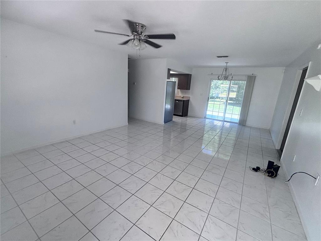 11806 Southeast 72nd Terrace Road Belleview, FL 34420 - Photo 3 of 13 wooden floor in an empty room with a window