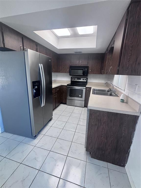 11806 Southeast 72nd Terrace Road Belleview, FL 34420 - Photo 5 of 13 a kitchen with stainless steel appliances a refrigerator and a sink
