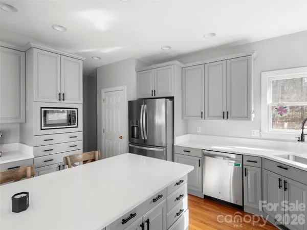 a open kitchen with stainless steel appliances kitchen island granite countertop a refrigerator and a stove top oven