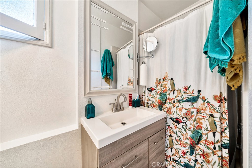 339 South Orange Street Orange, CA 92866 - Photo 36 of 52 a bathroom with a sink a mirror and a shower curtain