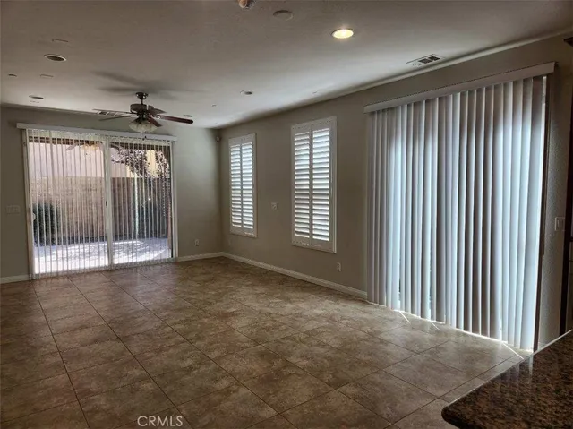 a view of an empty room with glass door and windows