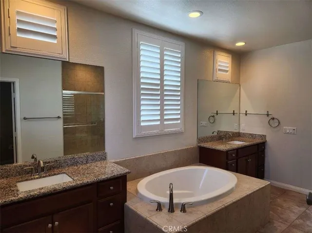 a bathroom with a tub sink and mirror