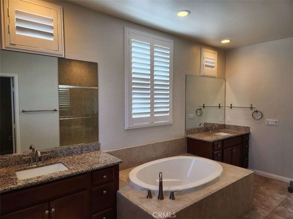 146 Violet Bloom Irvine, CA 92618 - Photo 22 of 25 a bathroom with a tub sink and mirror