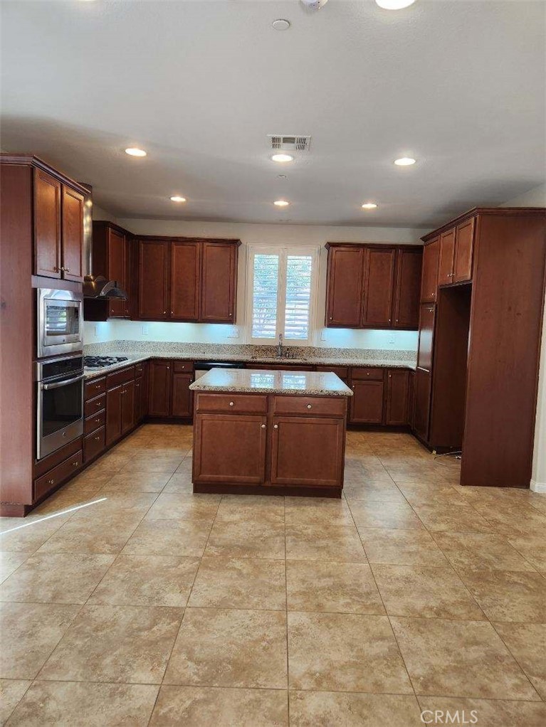 146 Violet Bloom Irvine, CA 92618 - Photo 4 of 25 a large kitchen with stainless steel appliances granite countertop a stove a sink dishwasher and a refrigerator