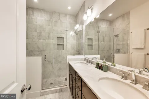 a bathroom with a granite countertop sink mirror and shower