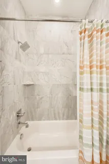 a bathroom with a shower and a bath tub