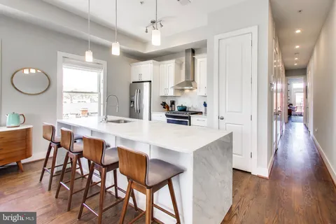 a large kitchen with a table and chairs