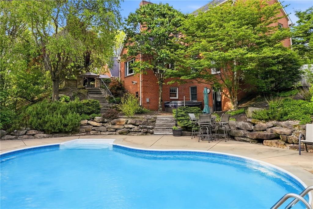 900 Settlers Ridge Road Pittsburgh, PA 15238 - Photo 44 of 50 The beauty of the heated saltwater pool is enhanced by the lush landscaping and picturesque backdrop of the home.