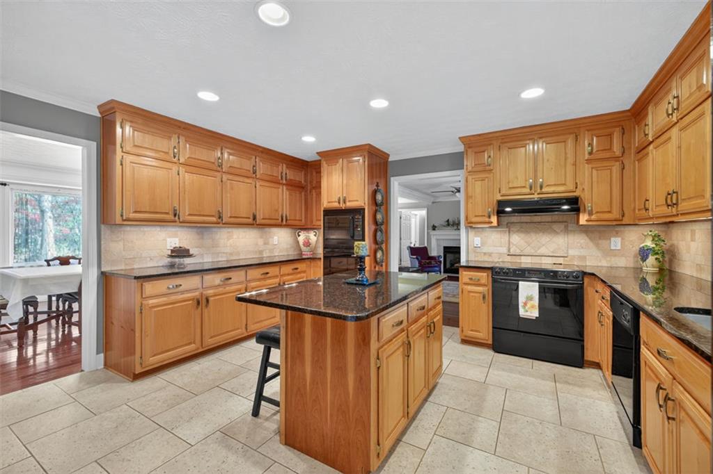 2150 Oglesby Bridge Road Southwest Conyers, GA 30094 - Photo 21 of 113 a kitchen with stainless steel appliances granite countertop wooden cabinets a sink and a stove