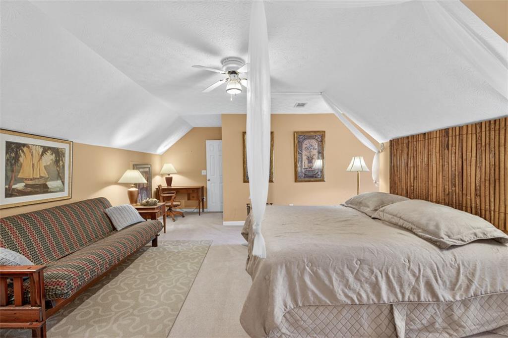 2150 Oglesby Bridge Road Southwest Conyers, GA 30094 - Photo 50 of 113 a spacious bedroom with a bed couch and painting on the wall