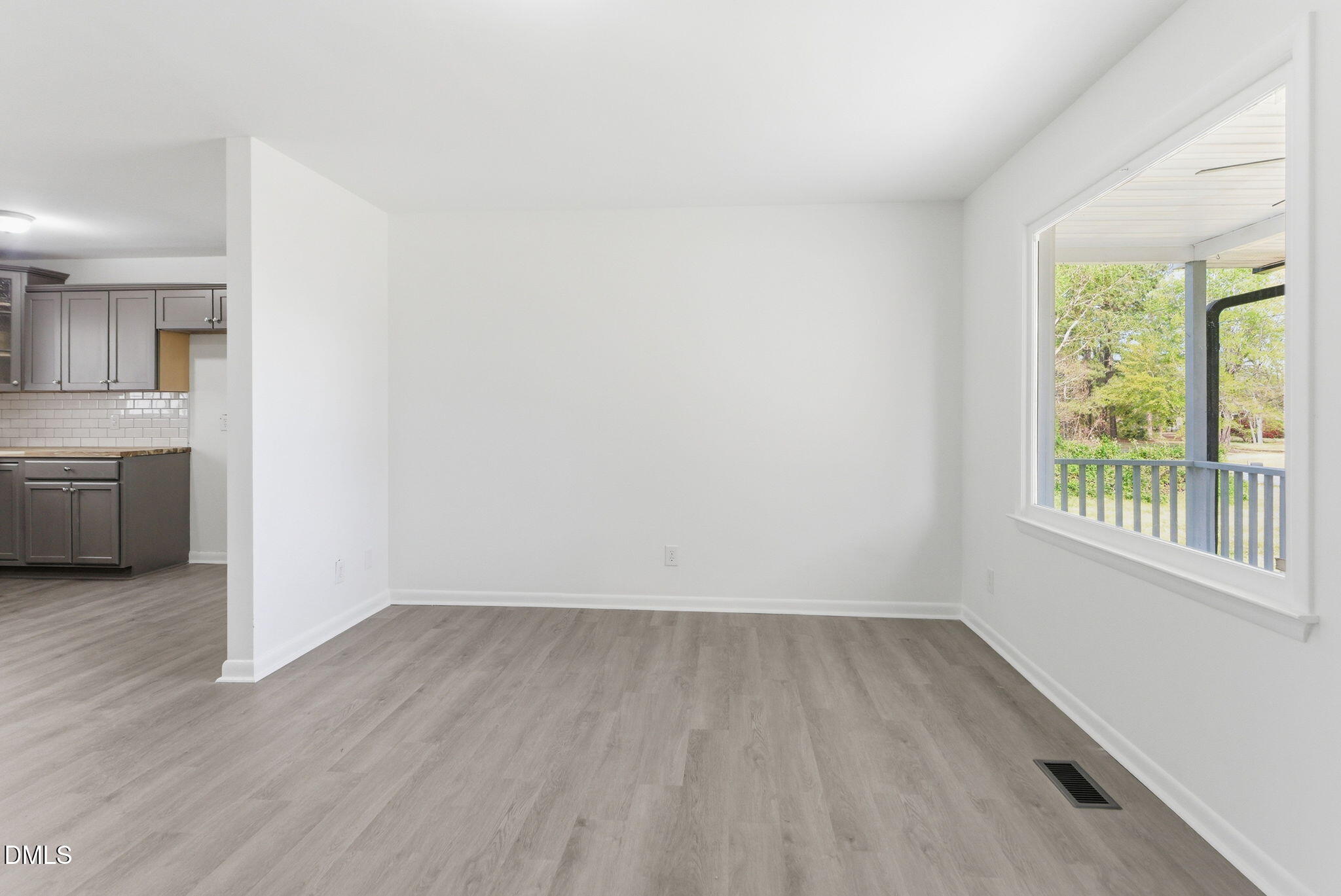 945 Old School Road Four Oaks, NC 27524 - Photo 12 of 37 an empty room with wooden floor and windows