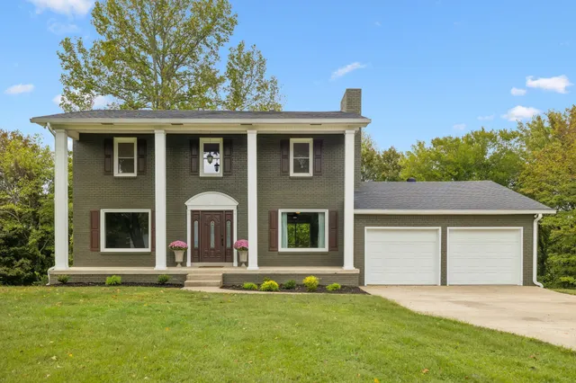 a front view of a house with a garden