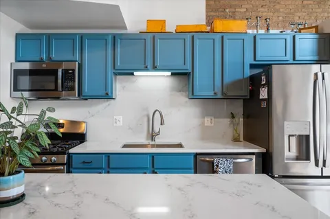 a kitchen with stainless steel appliances granite countertop a refrigerator a stove and a wooden cabinets