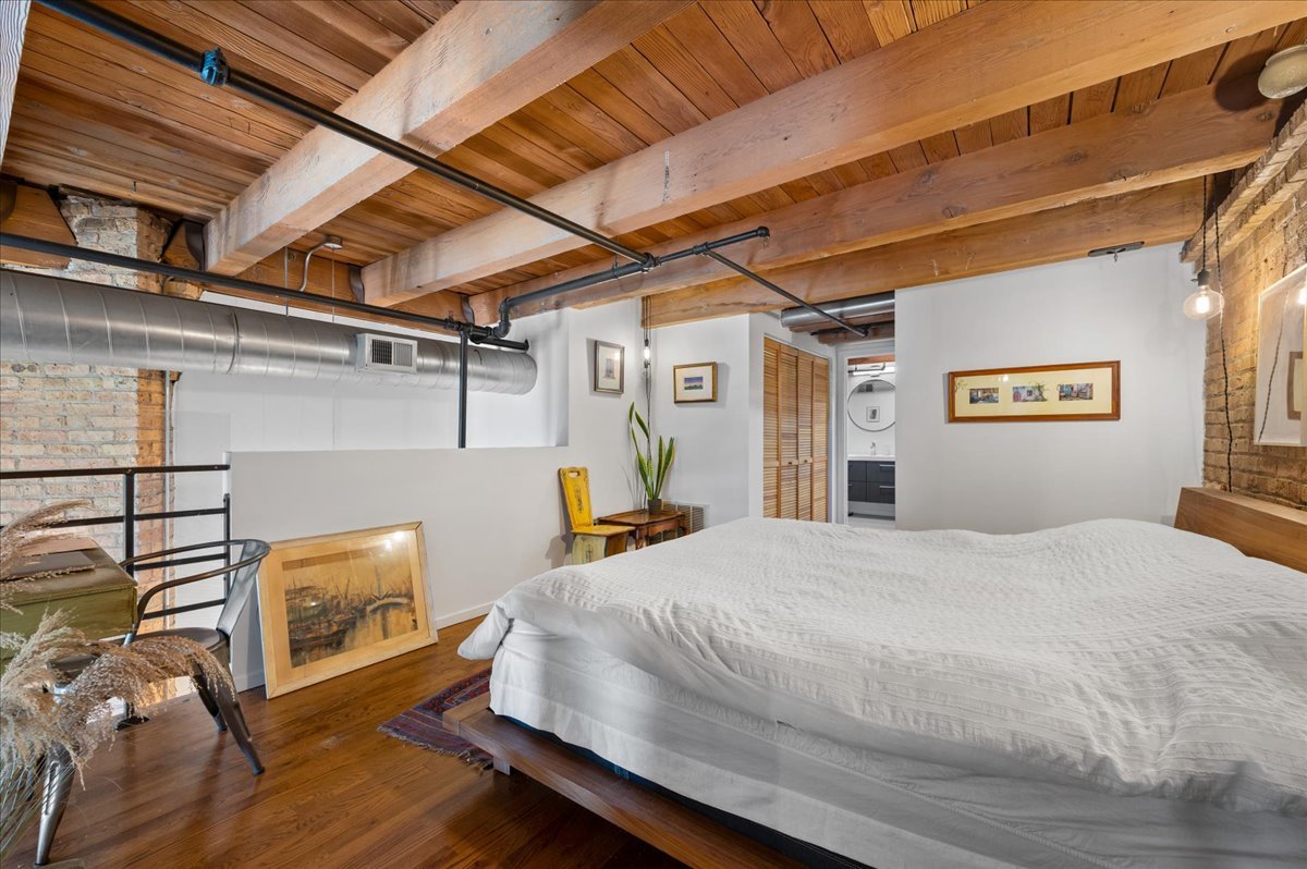 2161 North California Avenue, Unit 105 Chicago, IL 60647 - Photo 16 of 27 a bedroom with a bed and a tv