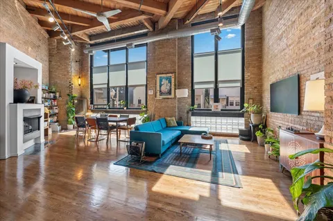 a living room with fireplace furniture and a large window