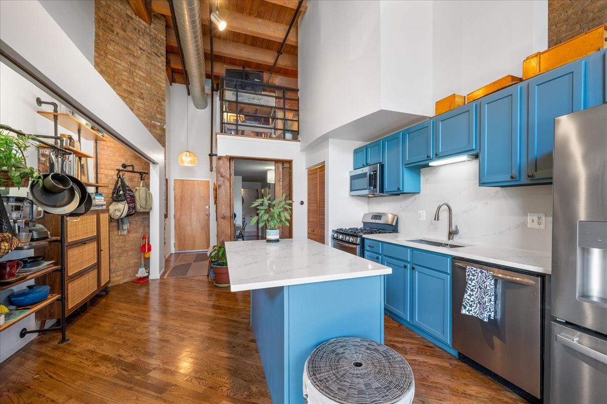 2161 North California Avenue, Unit 105 Chicago, IL 60647 - Photo 10 of 27 a kitchen with stainless steel appliances granite countertop a sink a stove and a wooden floors
