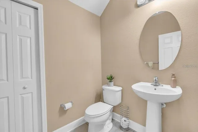 a bathroom with a sink toilet and a mirror