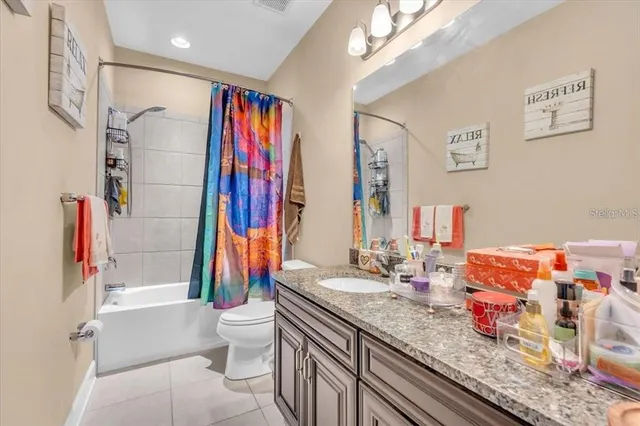 a bathroom with a granite countertop sink a toilet and shower
