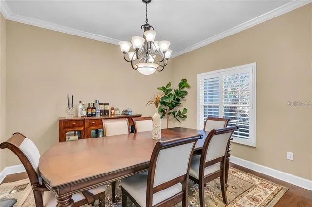 a view of a dining room with furniture a chandelier and wooden floor