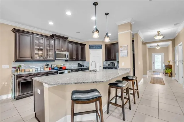 a kitchen with stainless steel appliances granite countertop a stove top oven a sink dishwasher a dining table and chairs with wooden floor