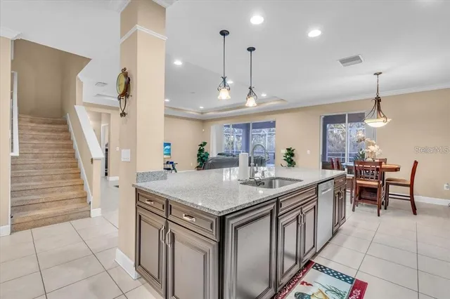 an open kitchen with a sink a counter space and a view of living room
