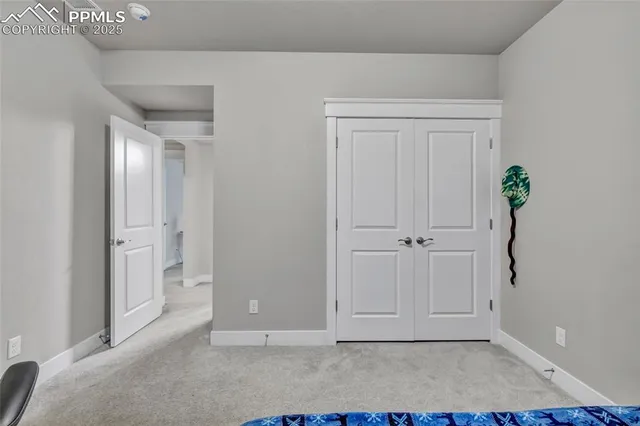 a bedroom with bed and a baby crib