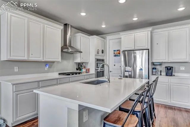 a kitchen with kitchen island white cabinets and stainless steel appliances