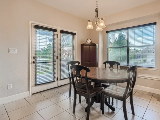 a dining room with furniture a chandelier and window