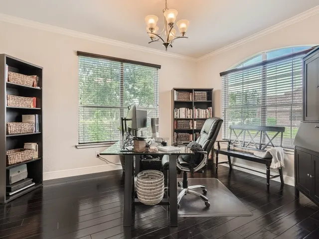 a view of a workspace with furniture and a large window