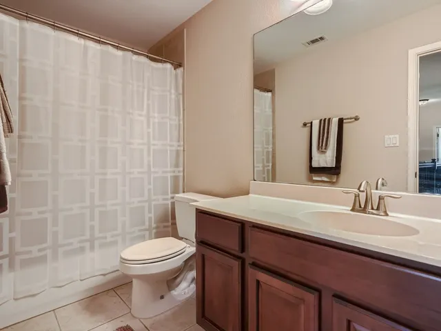 a bathroom with a sink a toilet a mirror and shower