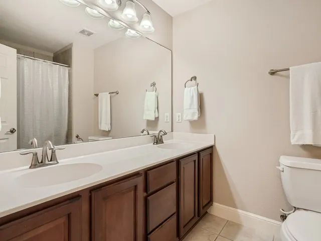 a bathroom with a double vanity sink and a mirror