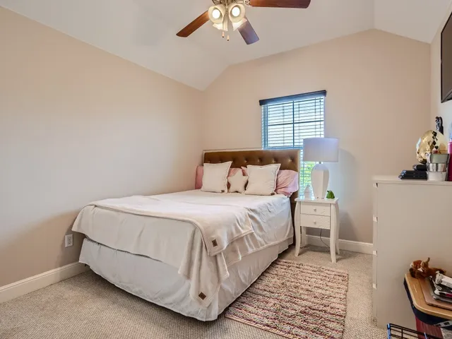 a bedroom with a bed lamp and a window
