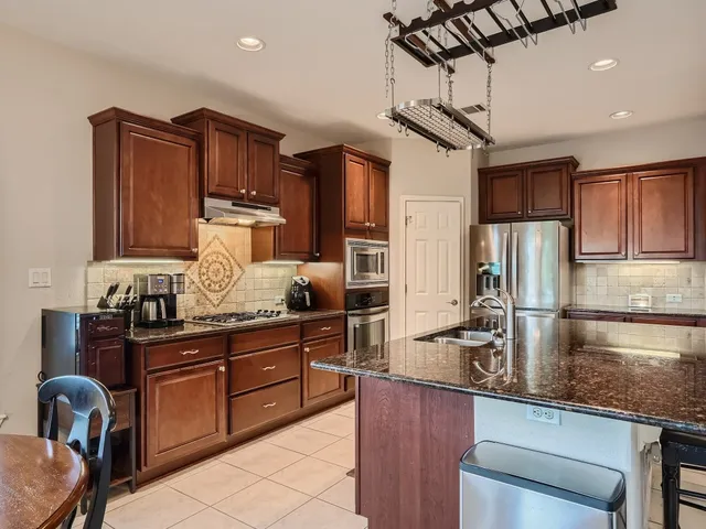 a kitchen with wooden cabinets and stainless steel appliances