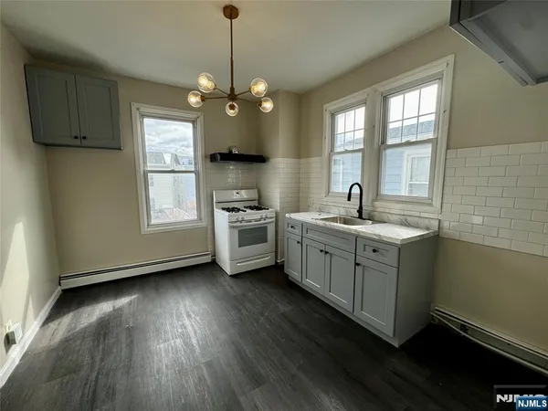 a kitchen with a sink window and stainless steel appliances