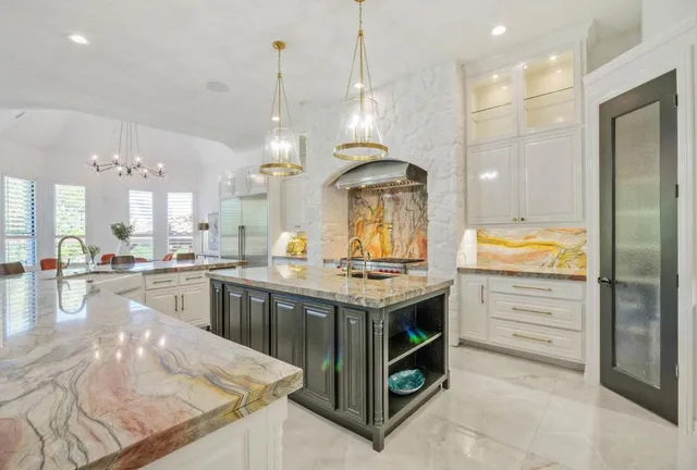 a kitchen with kitchen island granite countertop a large counter top and stainless steel appliances