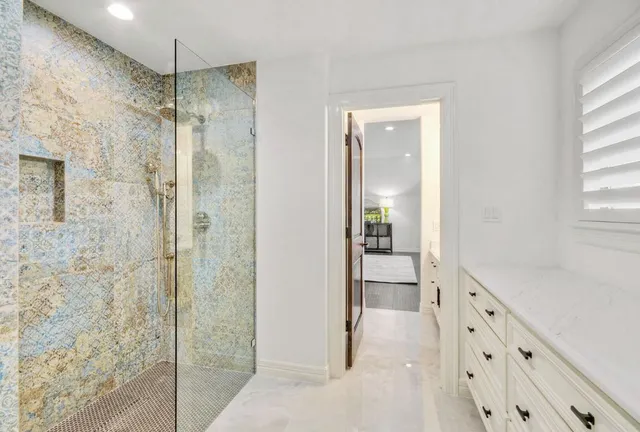 a bathroom with a glass shower door and a sink