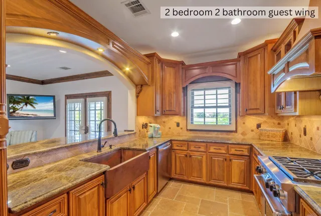 a kitchen with stainless steel appliances granite countertop a sink stove and cabinets